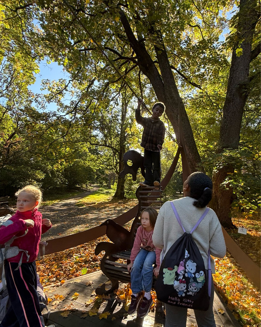En gruppe mennesker som står rundt en statue i en park